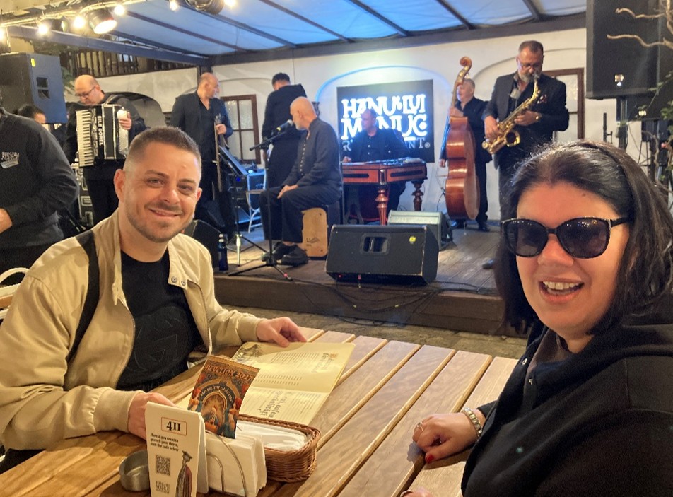 Izabella Dumitra, Head of the Cultural Service, inviting guests to a performance of traditional Romanian music at the historic Bucarest landmark, Hanul lui Manuc
