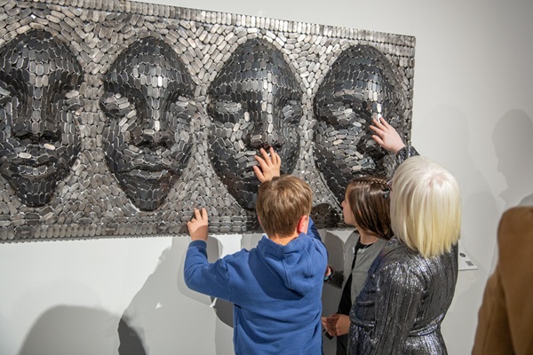Children and a woman touching tactile faces