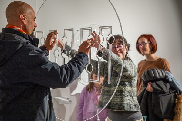 A man and a child on either side of a transparent plastic sculpture