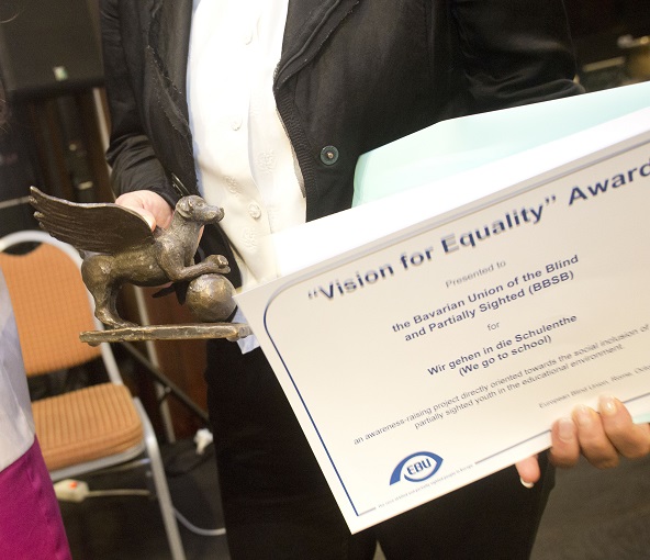 a close-up of the artwork and certificate. The work of art is a small bronze sculpture of a dog with wings